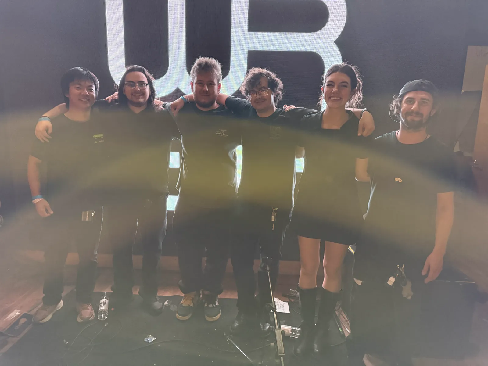 Six WREK student crew members standing together in front of a large WREK projection.