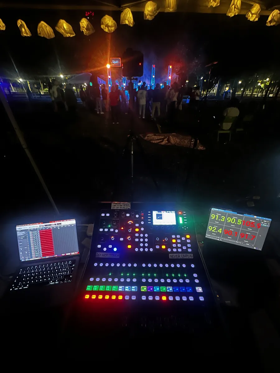 A front-of-house mixing console overlooking a live audience and stage.